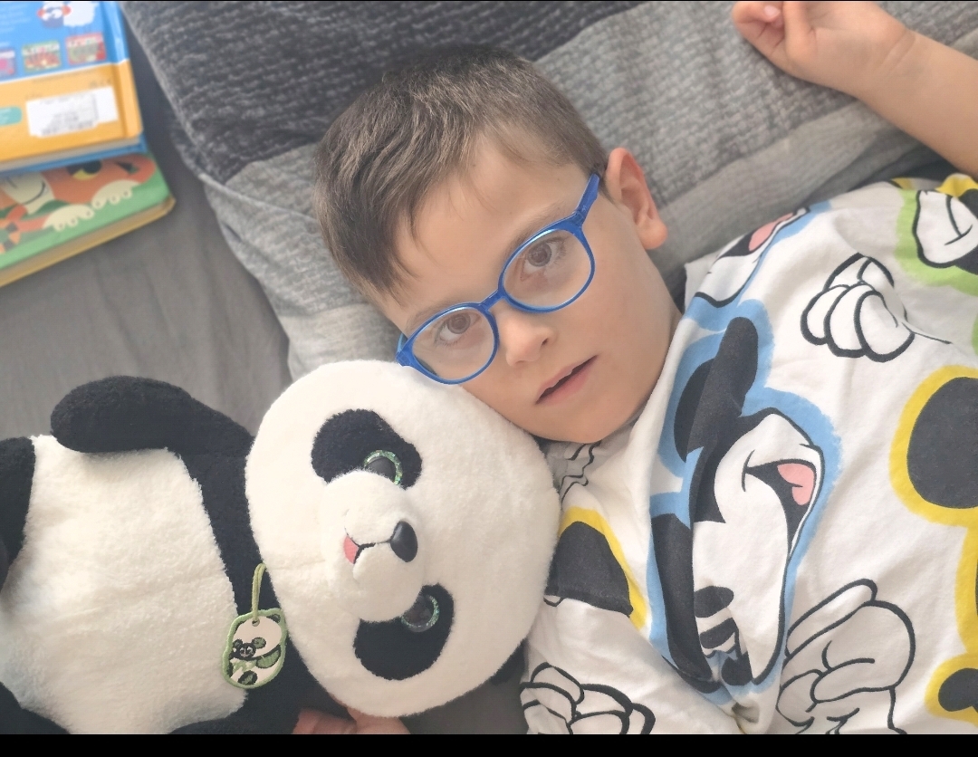 Alan przytulający swoją maskotkę pandę